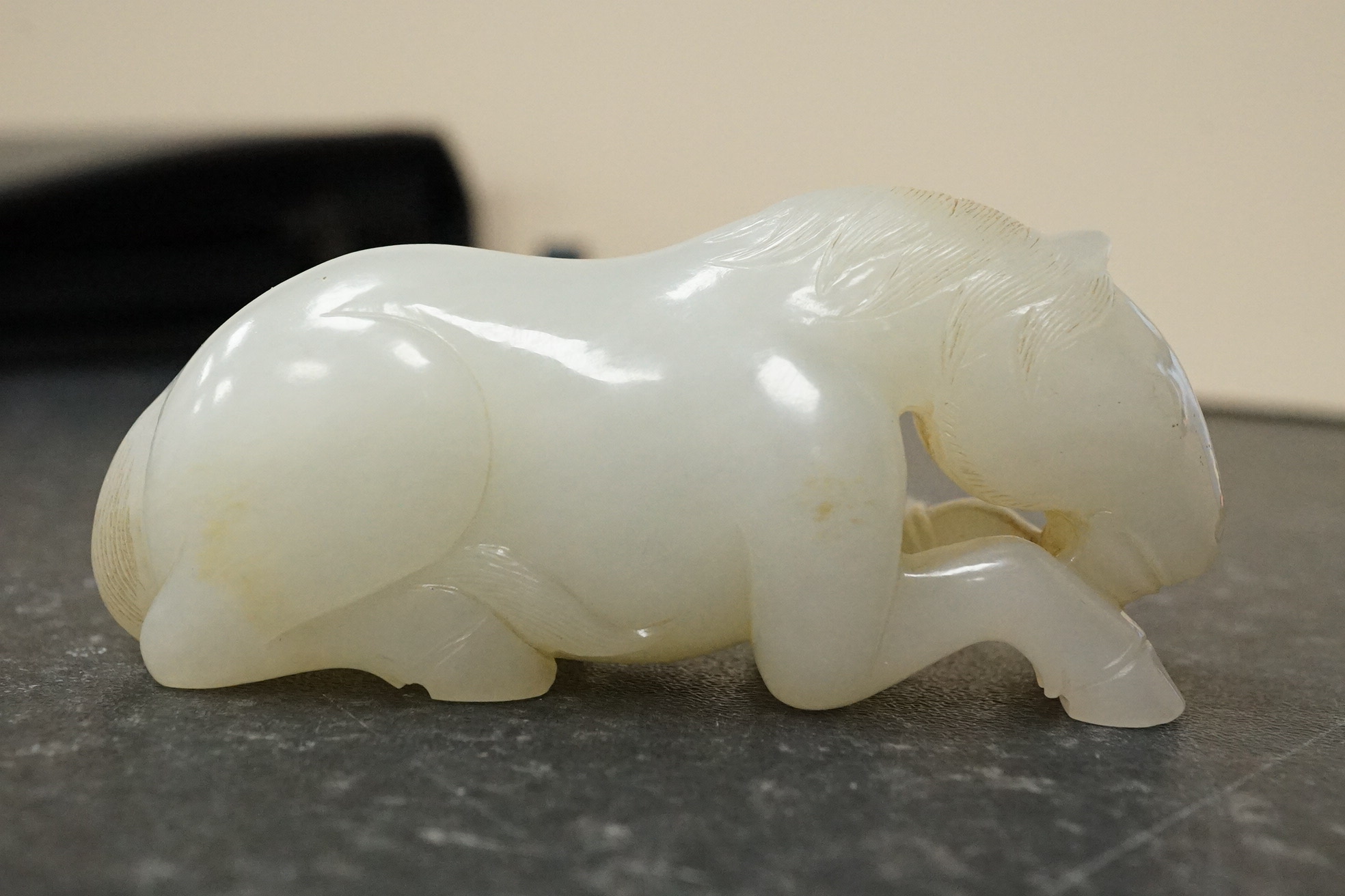 A Chinese white jade figure of a recumbent horse
